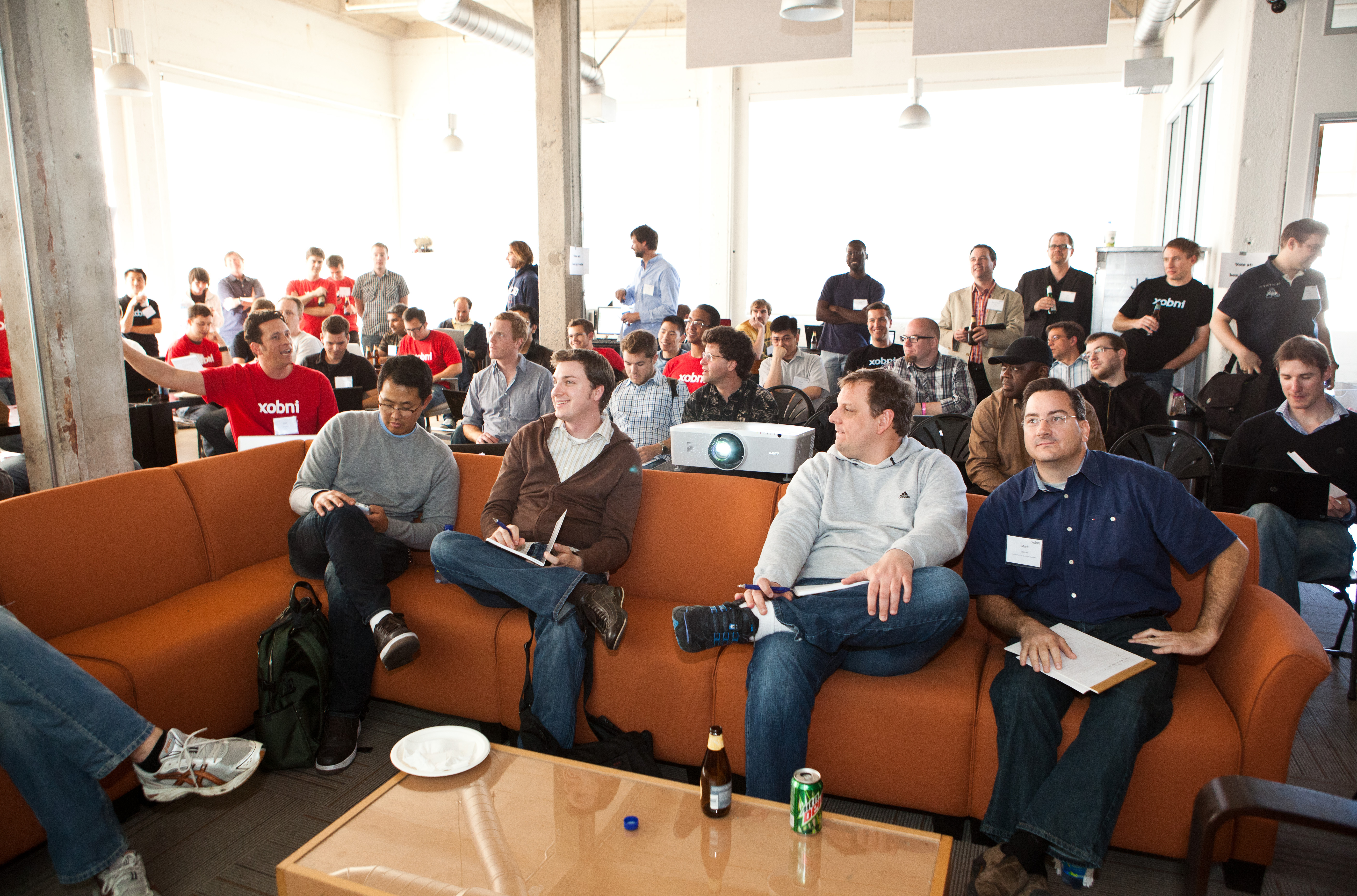 Judges and attendees gathered on a couch and around laptops at Xobni’s 2011 Gadget Hack Day