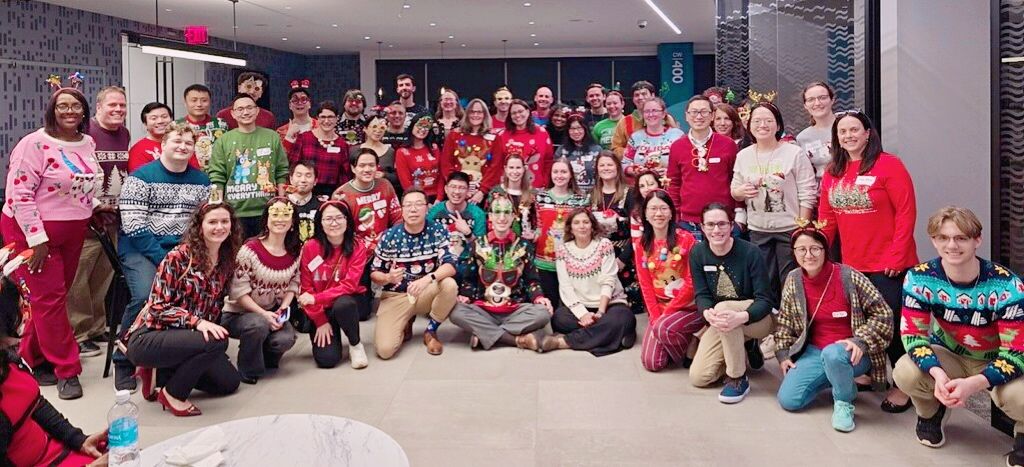 Equitable colleagues gathered in festive sweaters at their 2024 team event