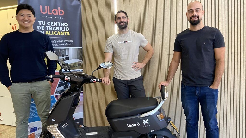 Xulei Xu and two collaborators standing with a NEXT electric scooter at ULab in Alicante
