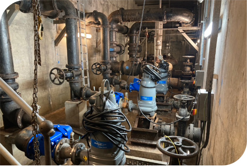 Flygt wastewater pumps connected to pipework inside Llannech Wastewater Pumping Station