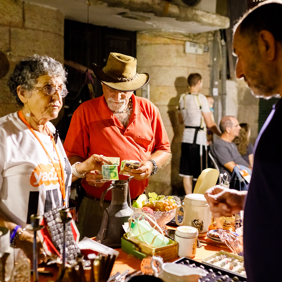 People buying and selling household objects at a Yad2 Live market