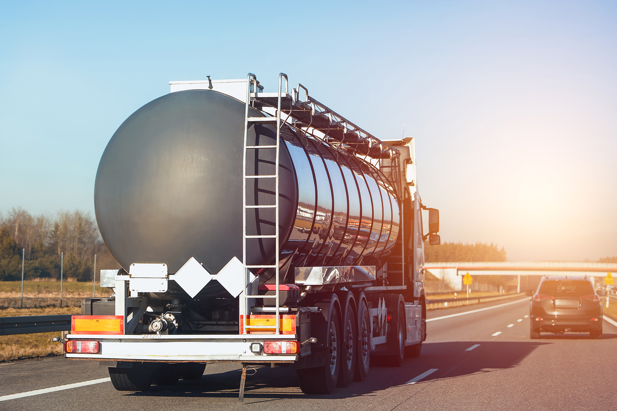 Fuel tanker traveling on a divided highway through open countryside