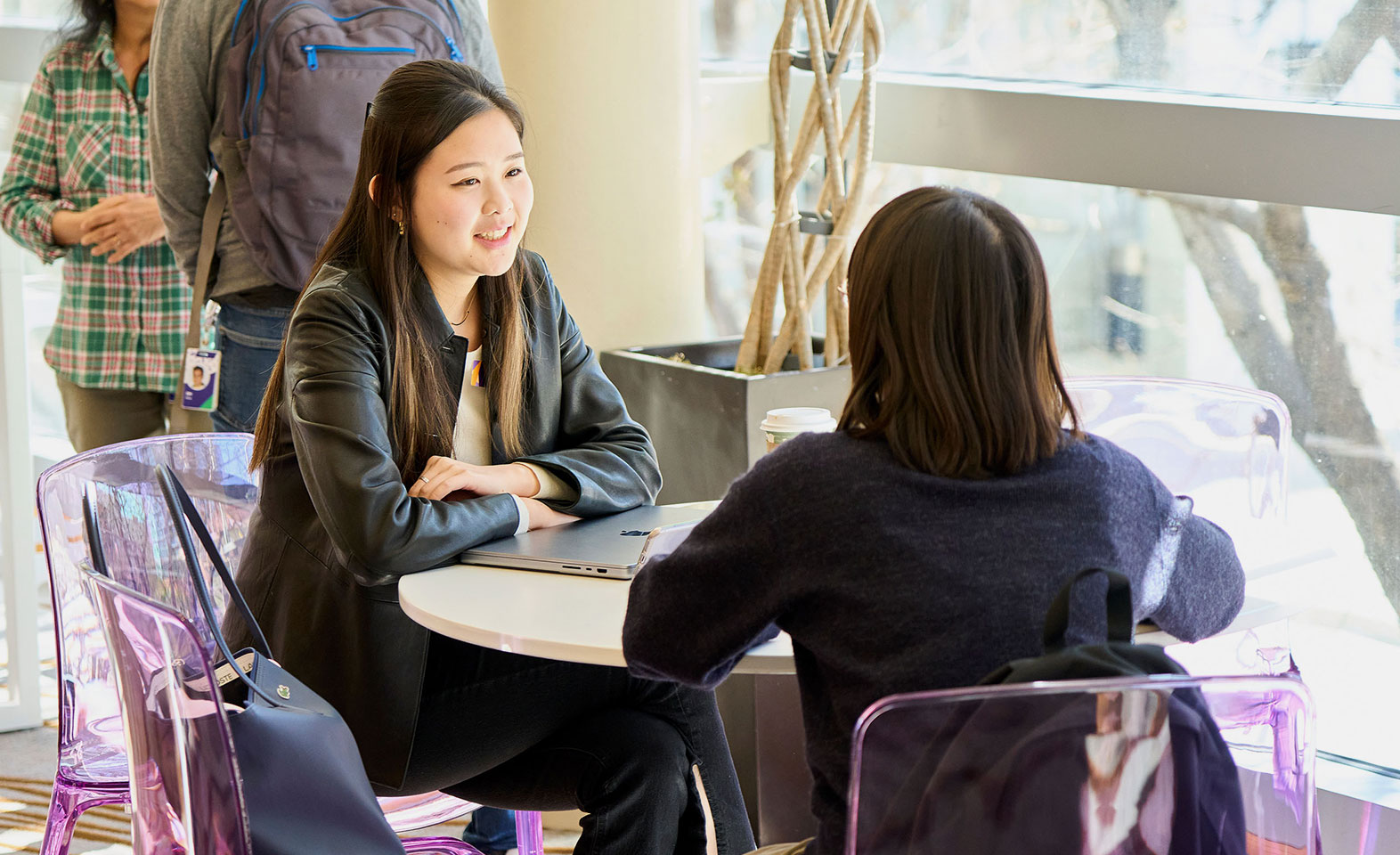Two people talking at a table in an office, pictured in Yahoo careers materials