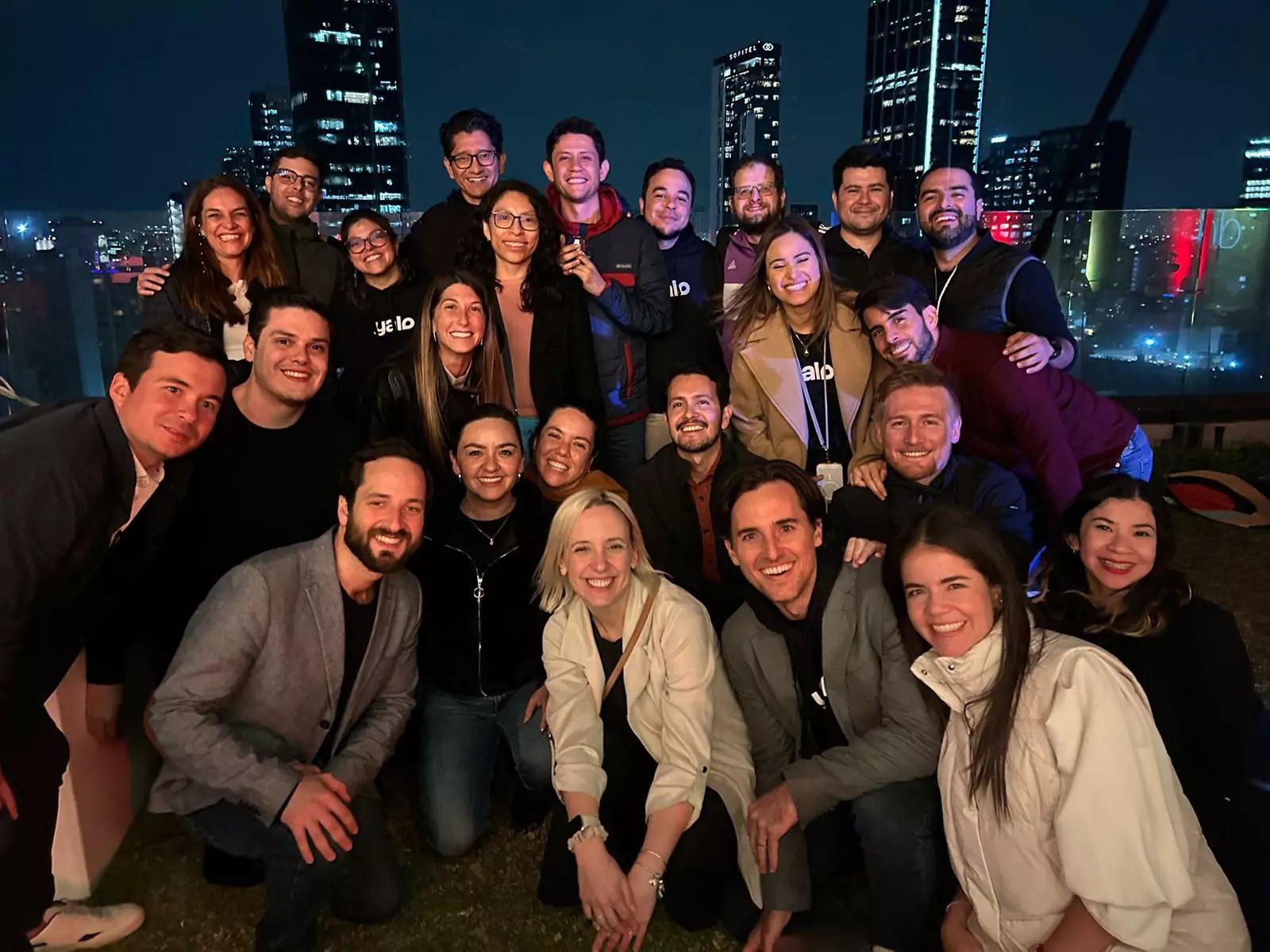 Yalo employees gathered on a rooftop at night