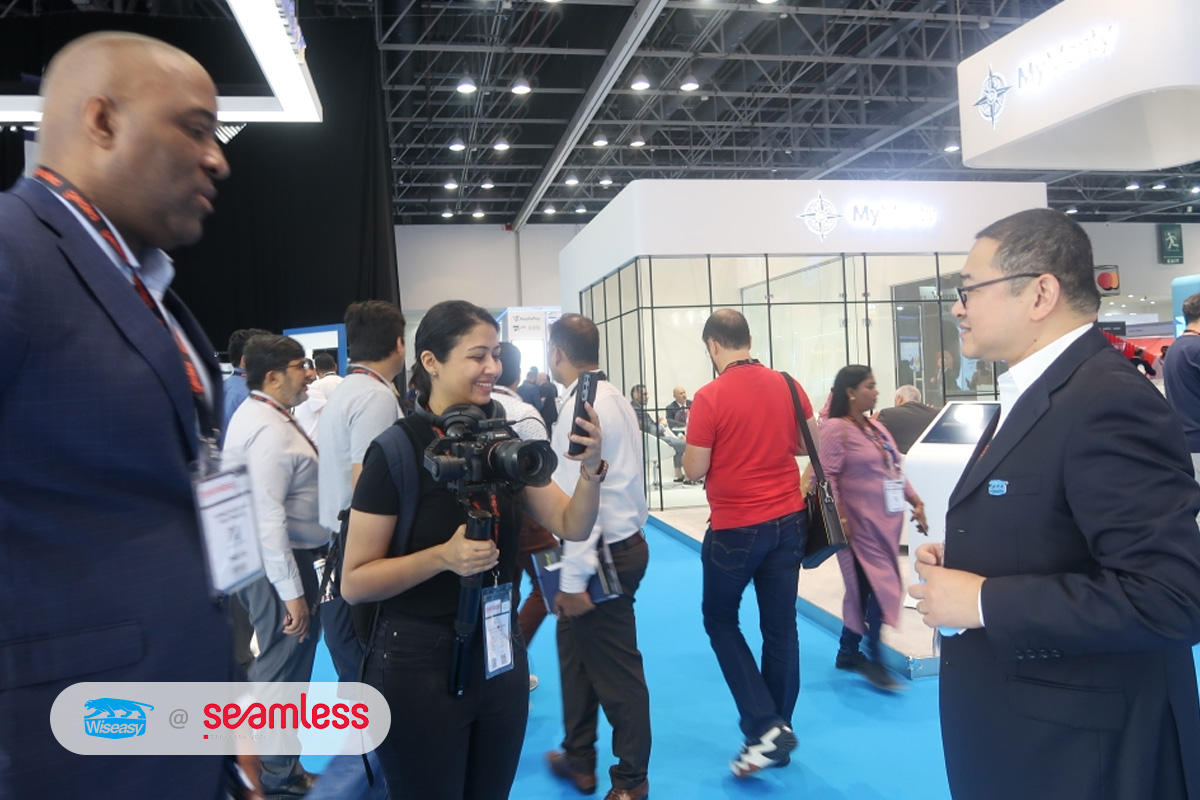 Yan Li, at right, speaking with an interviewer on the exhibition floor at Seamless Middle East 2023
