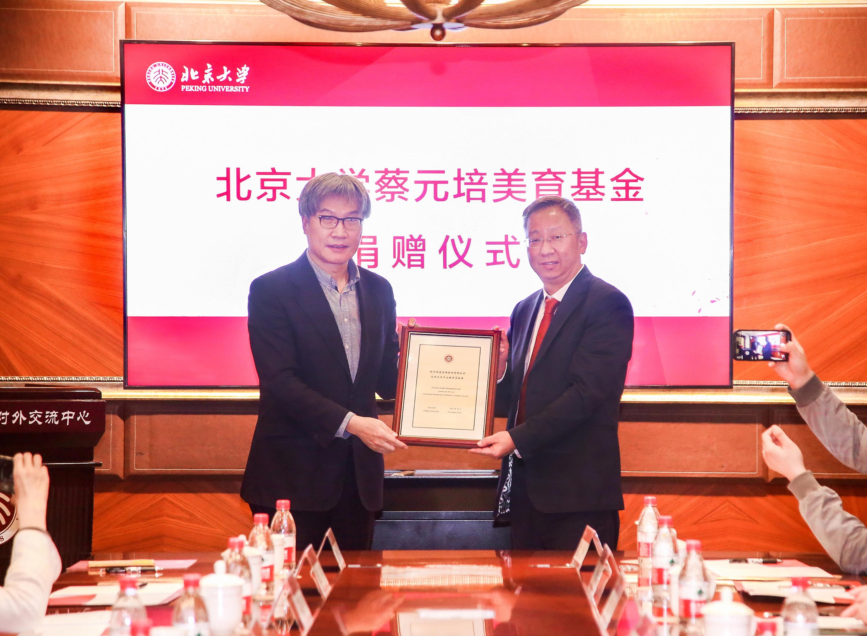 Wang Bo, left, presenting an education contribution award to Yang Wenbin at Peking University