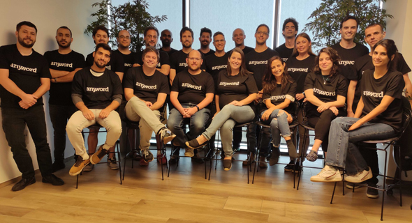 The Anyword team posing together in matching black company T-shirts in 2021