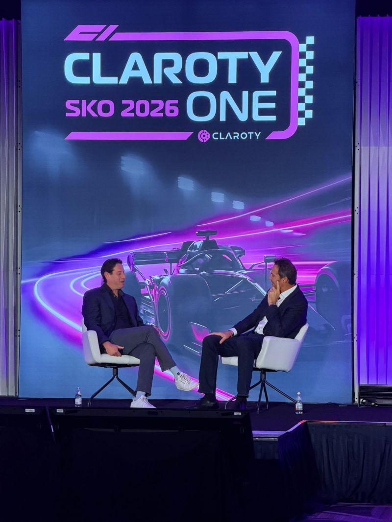 Yaniv Vardi and Dave DeWalt seated onstage at Claroty’s racing-themed 2026 sales kickoff