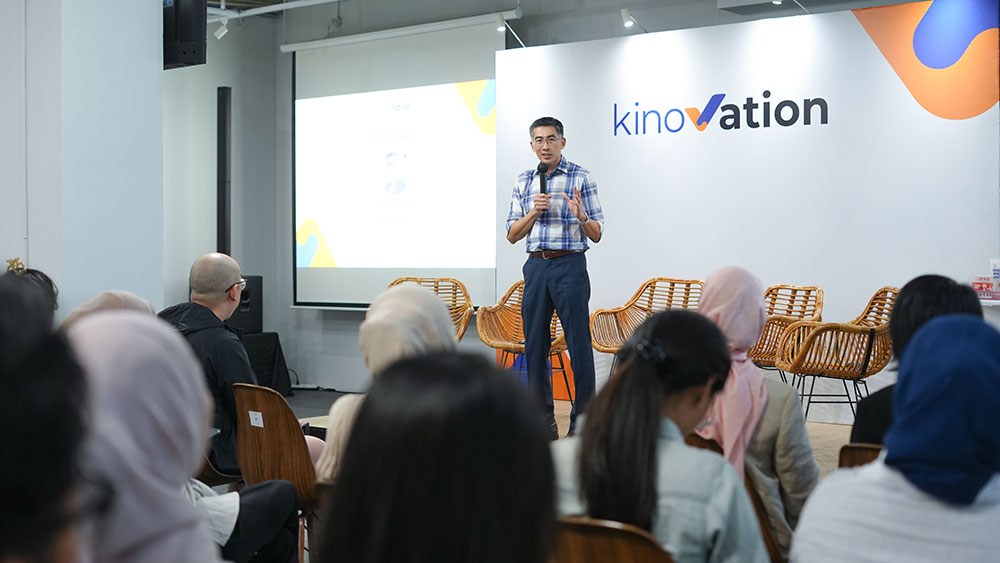 Yansen Kamto seated among attendees listening to a speaker at a Kinovation event