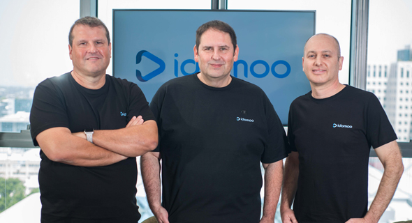 Idomoo’s three founders wearing black company T-shirts in an office