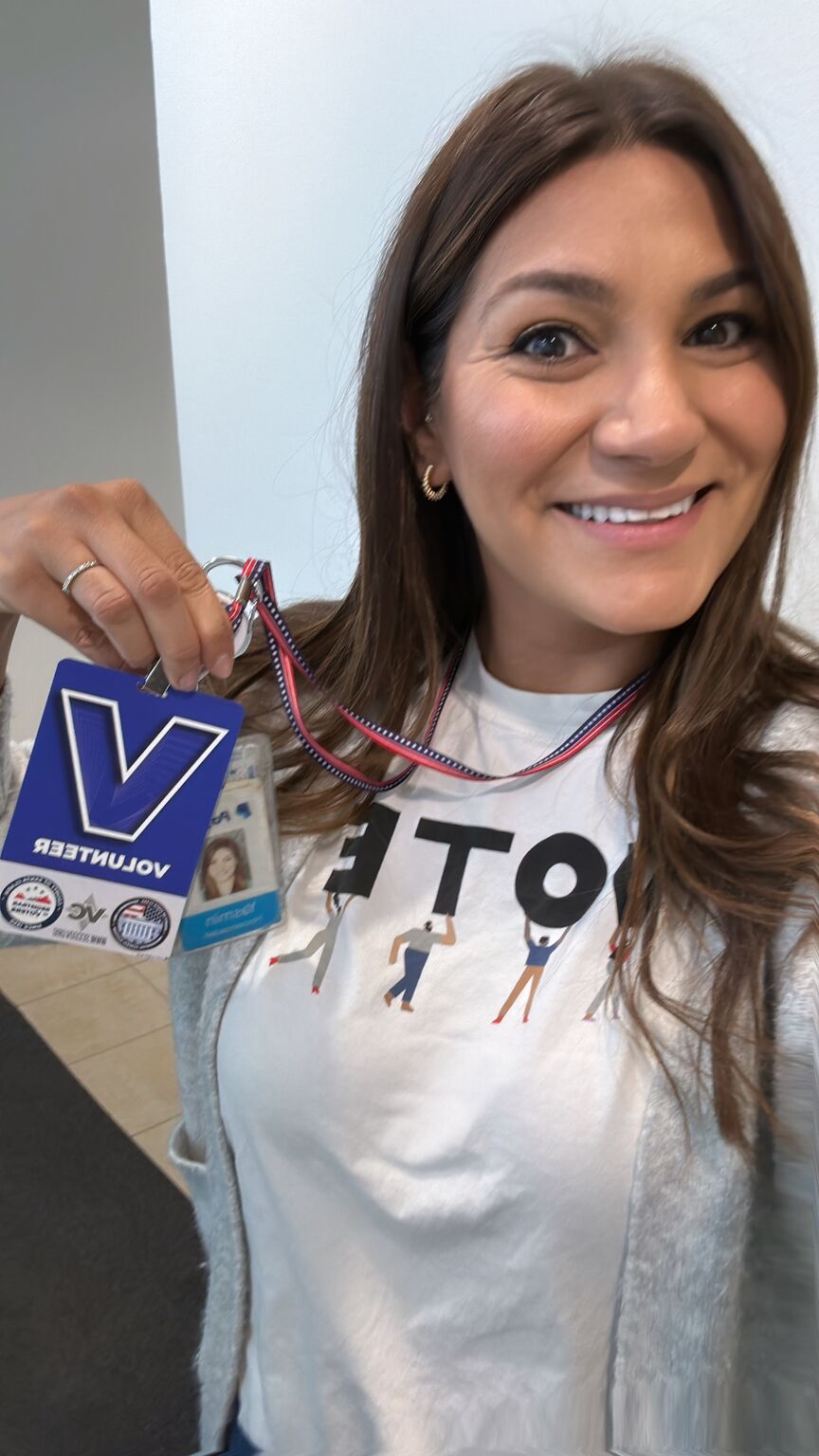 Yasmin Hosseinzadeh holding her volunteer badge in her election-day photograph