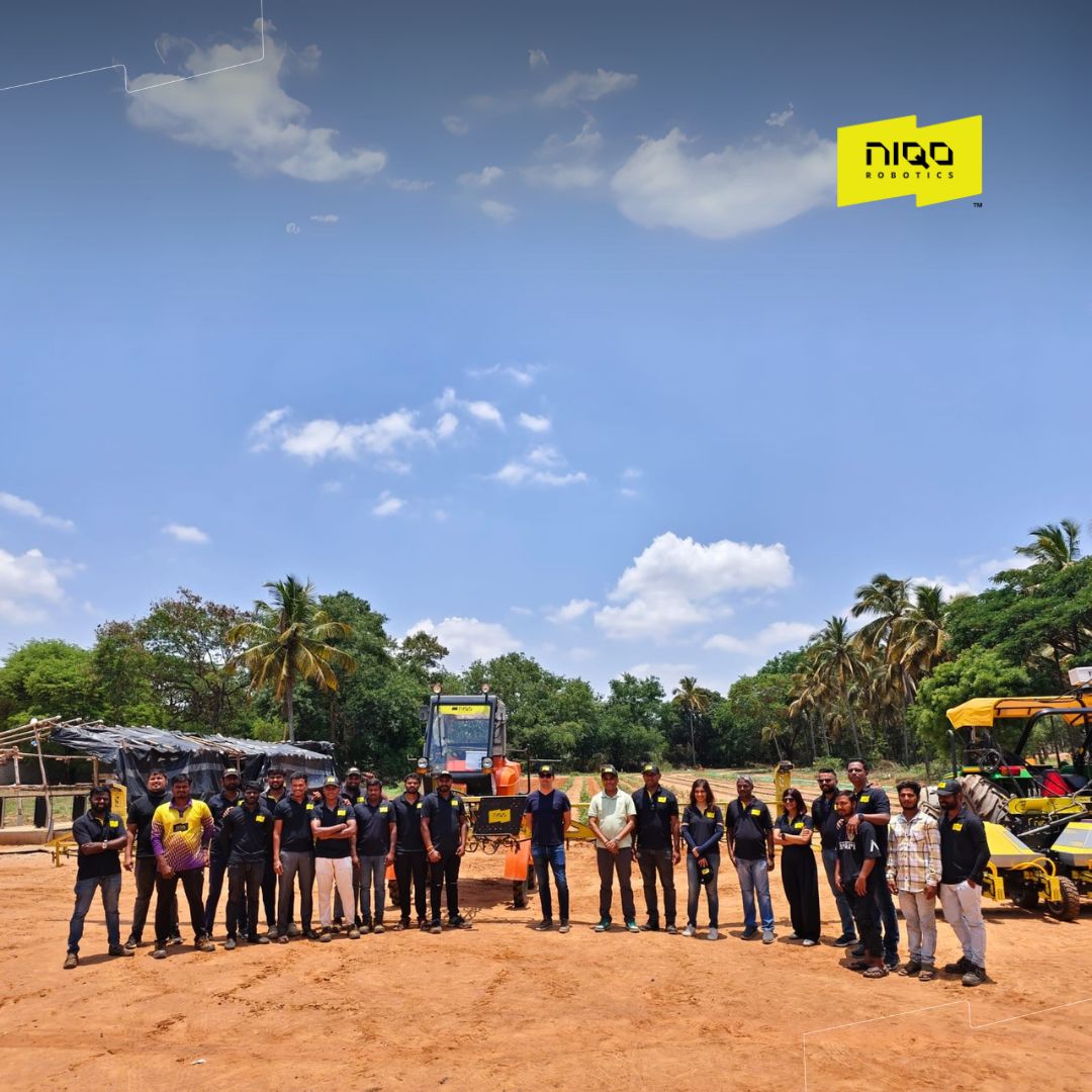 The Niqo Robotics team and visiting investors gathered beside farm machinery at the May 2025 demonstration