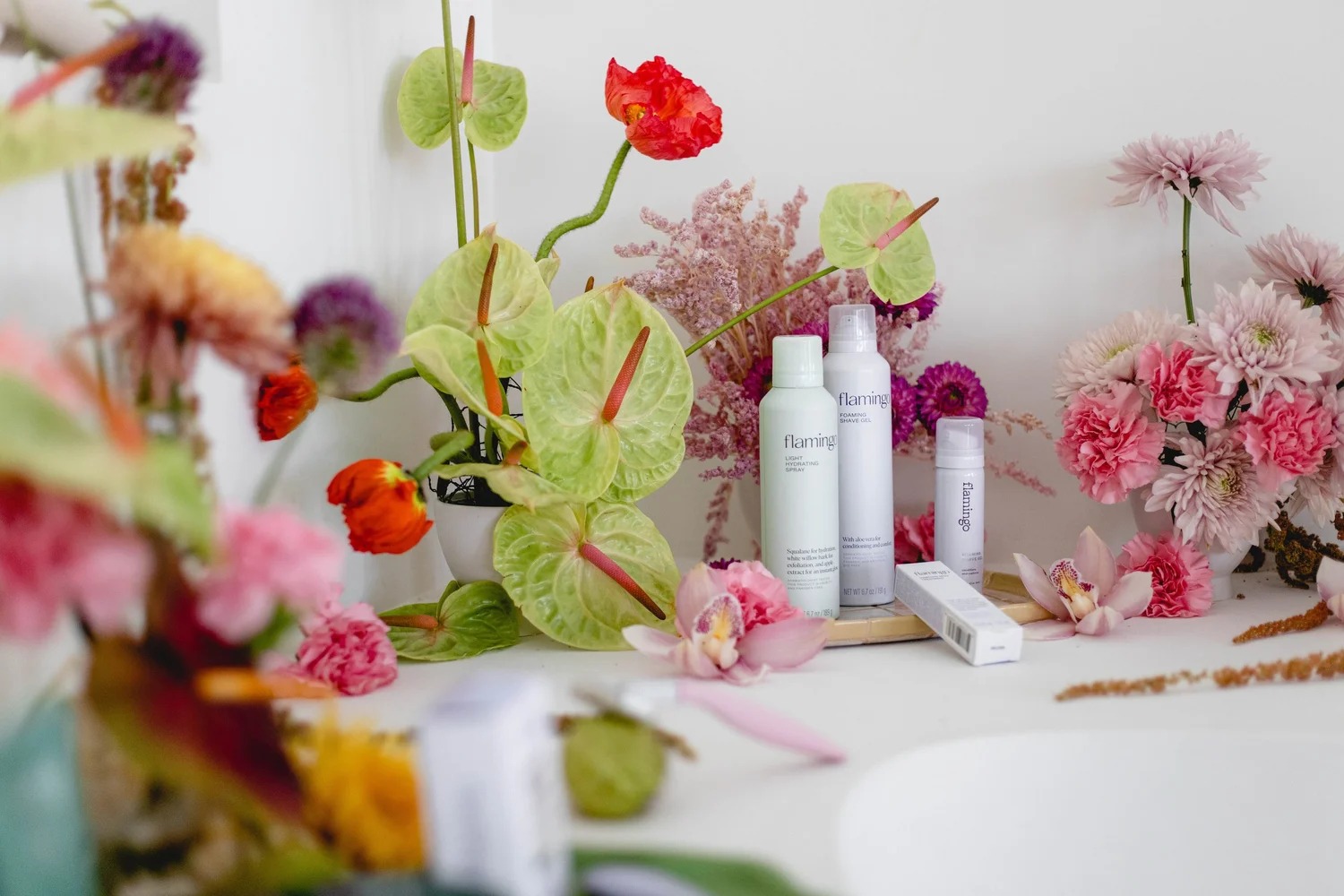 Flamingo body-care products arranged among colorful flowers at the Your Body in Mind experience