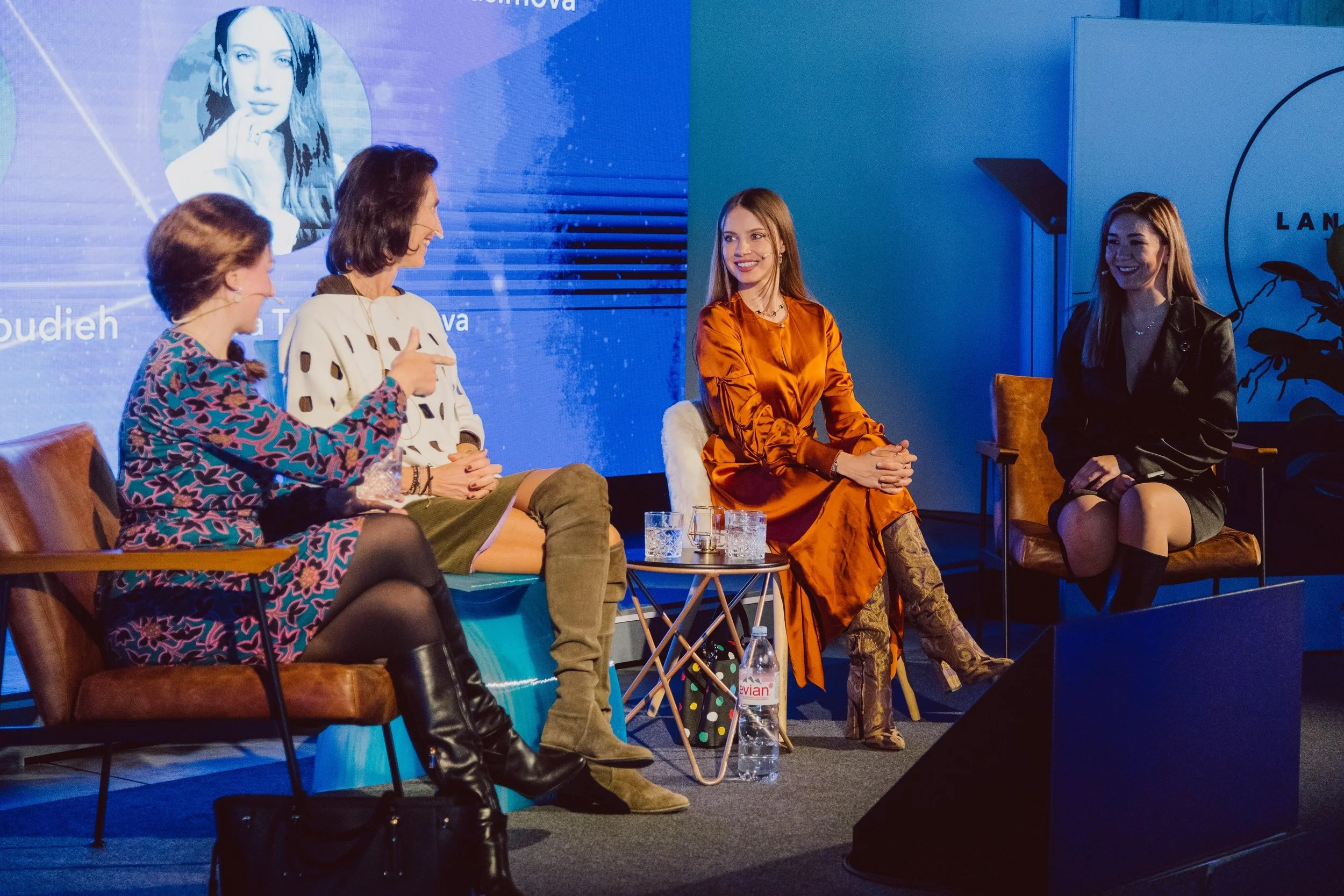 Four participants seated in conversation on an event stage