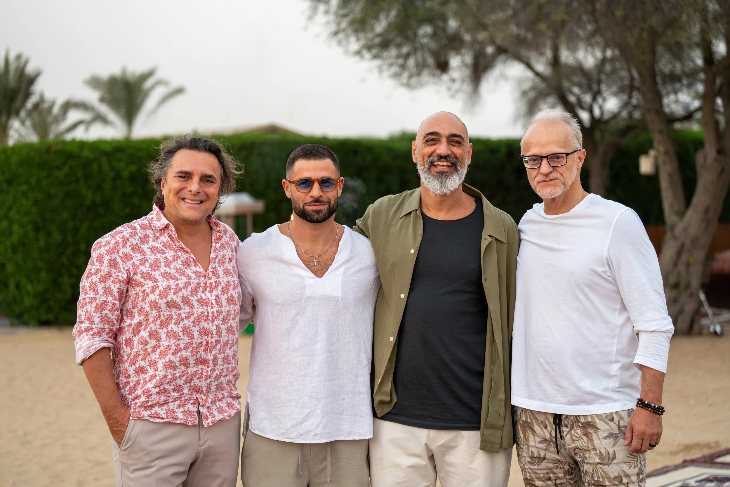Four House of Trust participants posing outdoors at a Dubai gathering