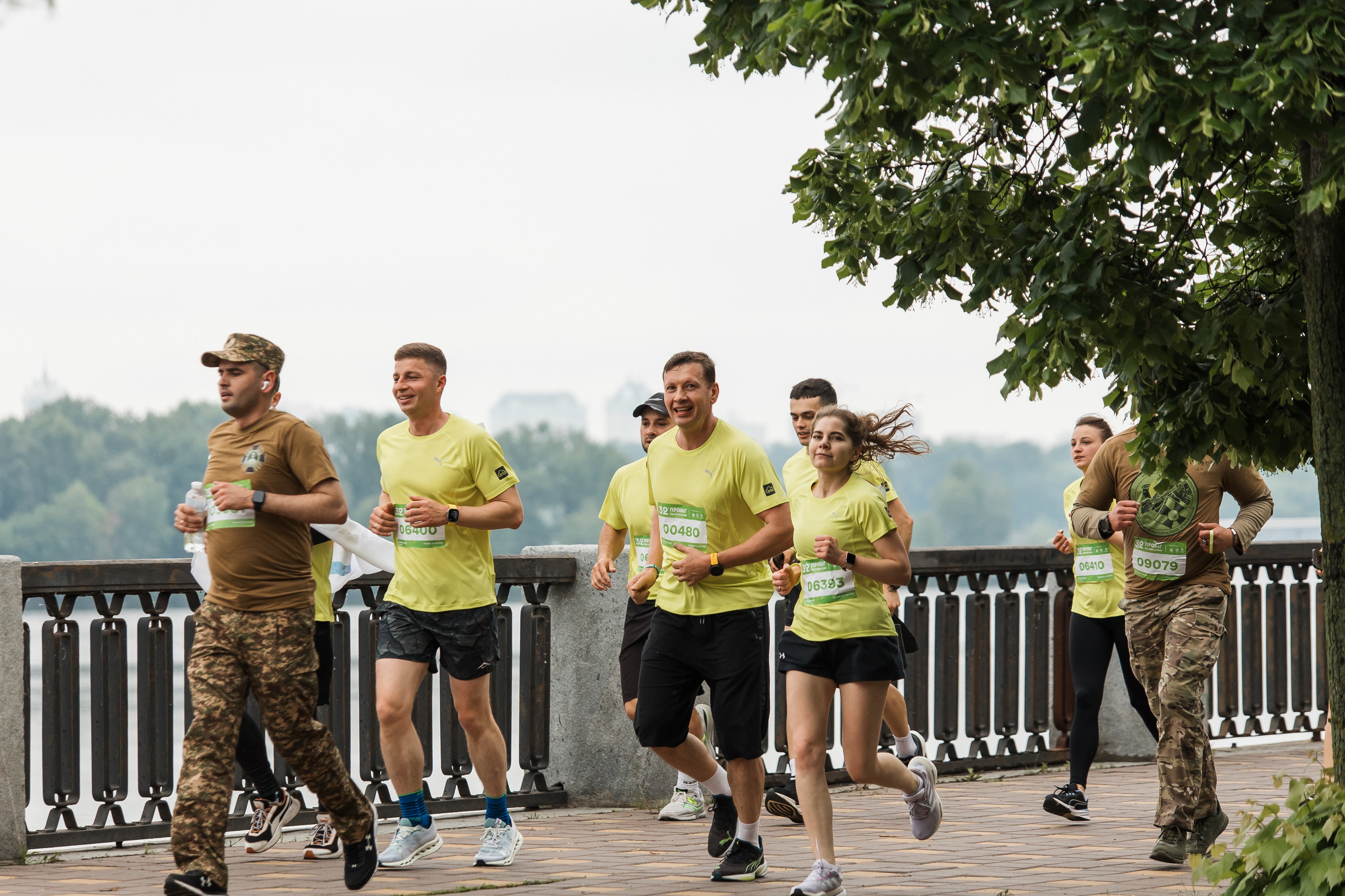Yevhen Donets, second from left, running with a group beside a riverside railing
