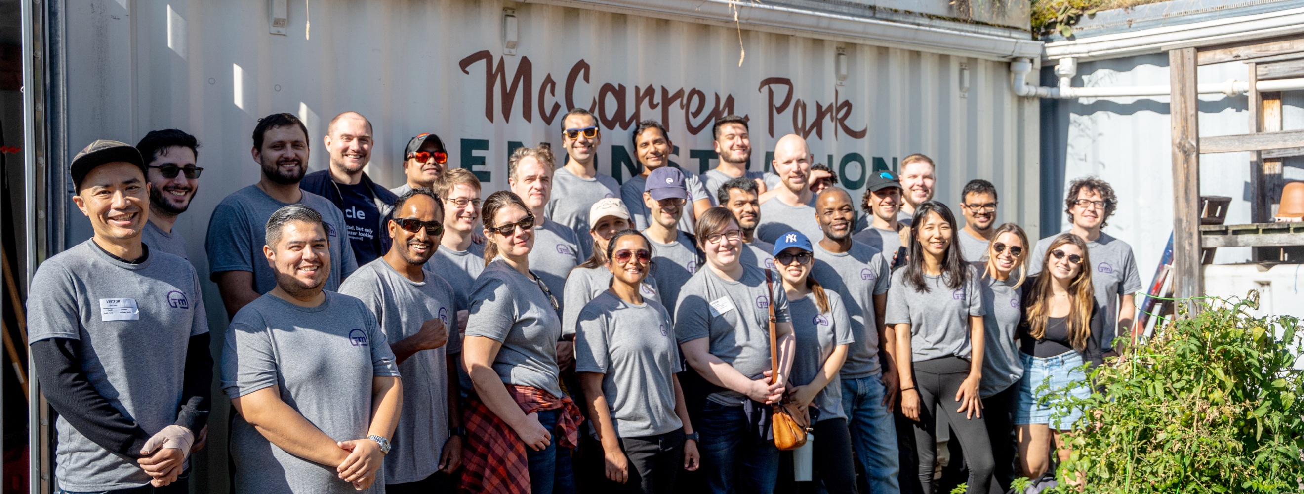Yieldmo team members gathered outdoors in front of a McCarren Park sign