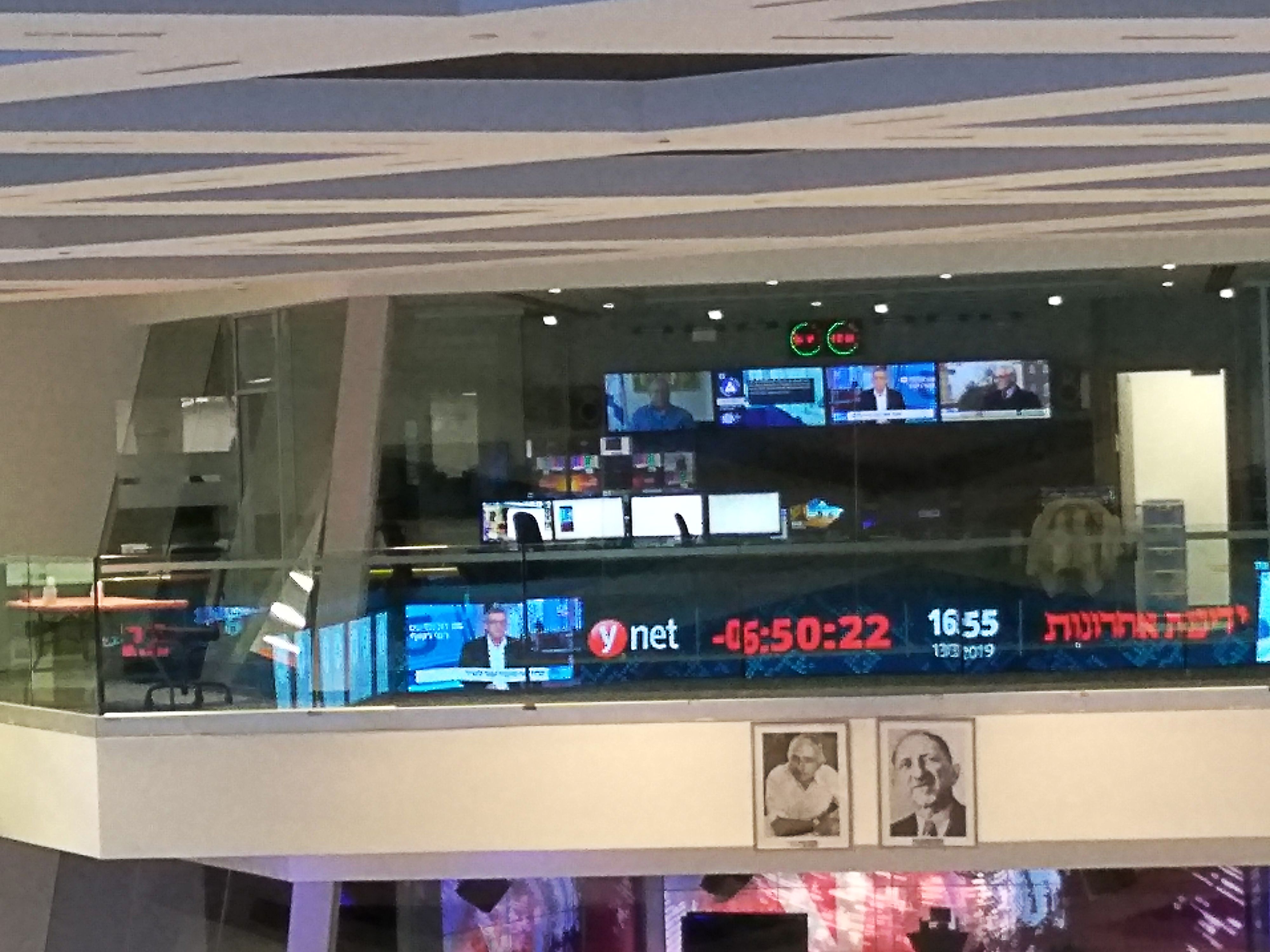 Monitors and broadcast equipment behind the glass of ynet’s control room in Rishon LeZion in 2019