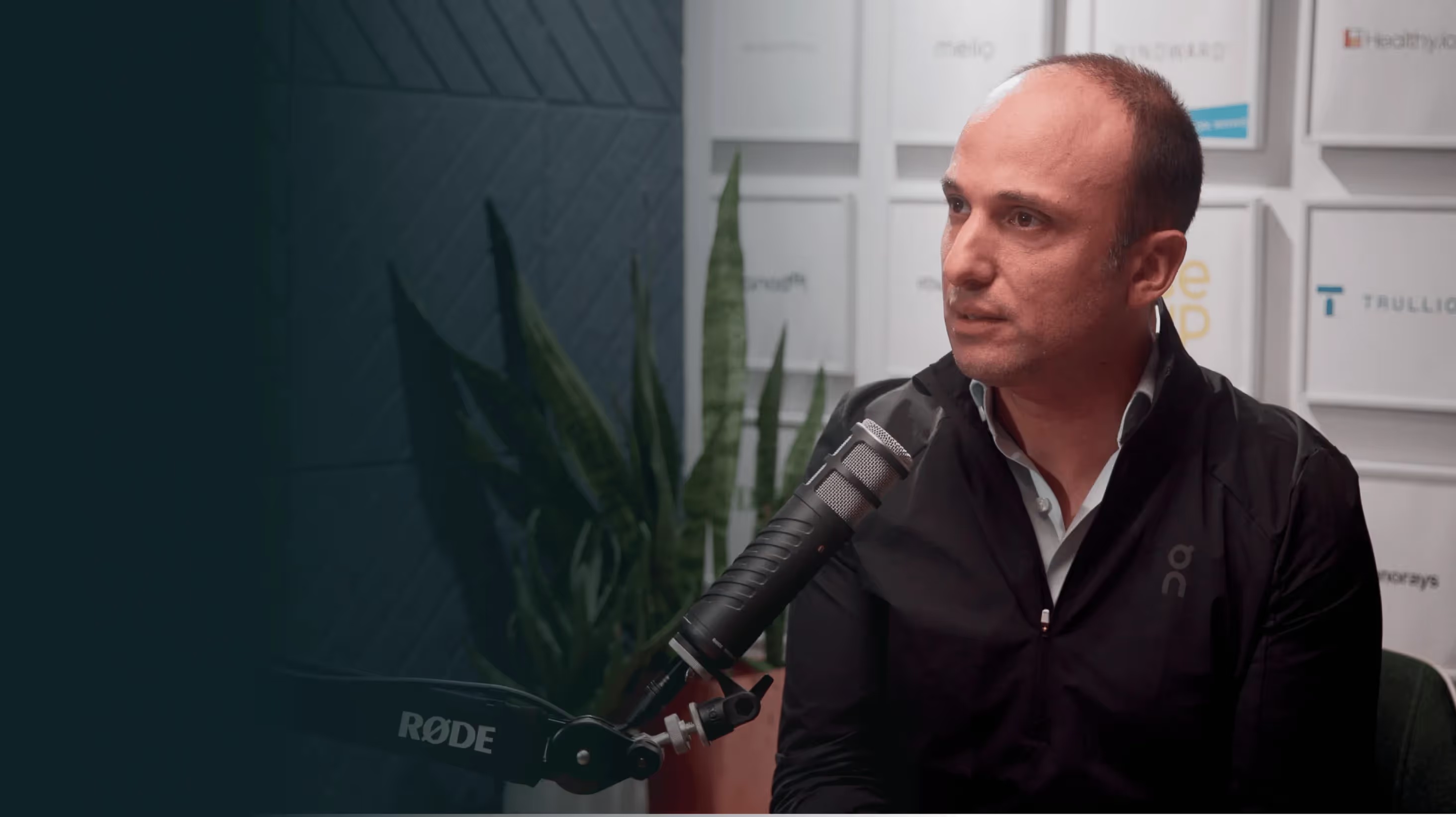Yonatan Adiri speaking into a studio microphone during his Invested interview