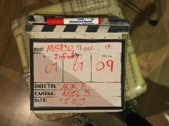 A Musico production clapperboard resting on a patterned chair