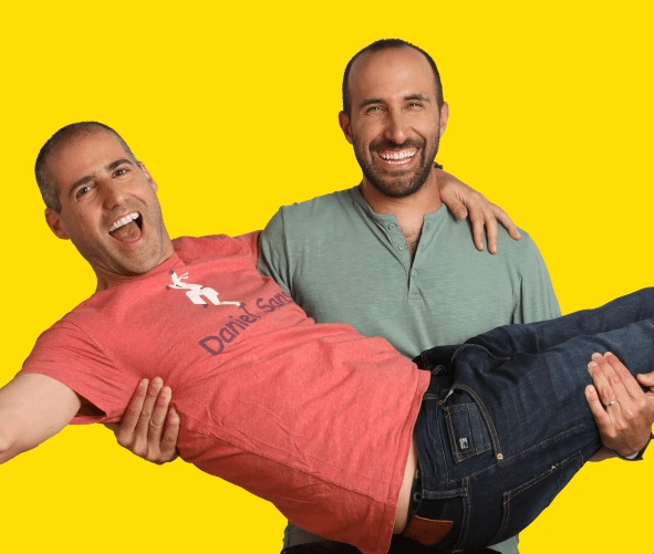 Lusha co-founders Yoni Tserruya and Assaf Eisenstein posing playfully against a yellow background