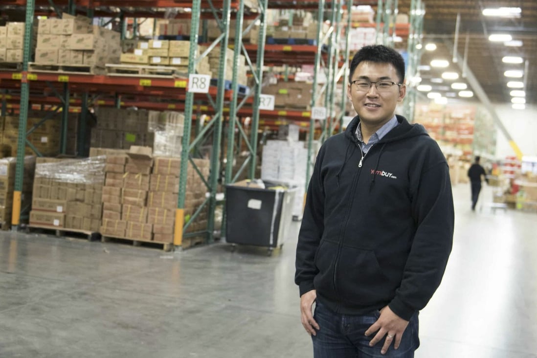 You Zhou standing between tall warehouse racks filled with Yami inventory
