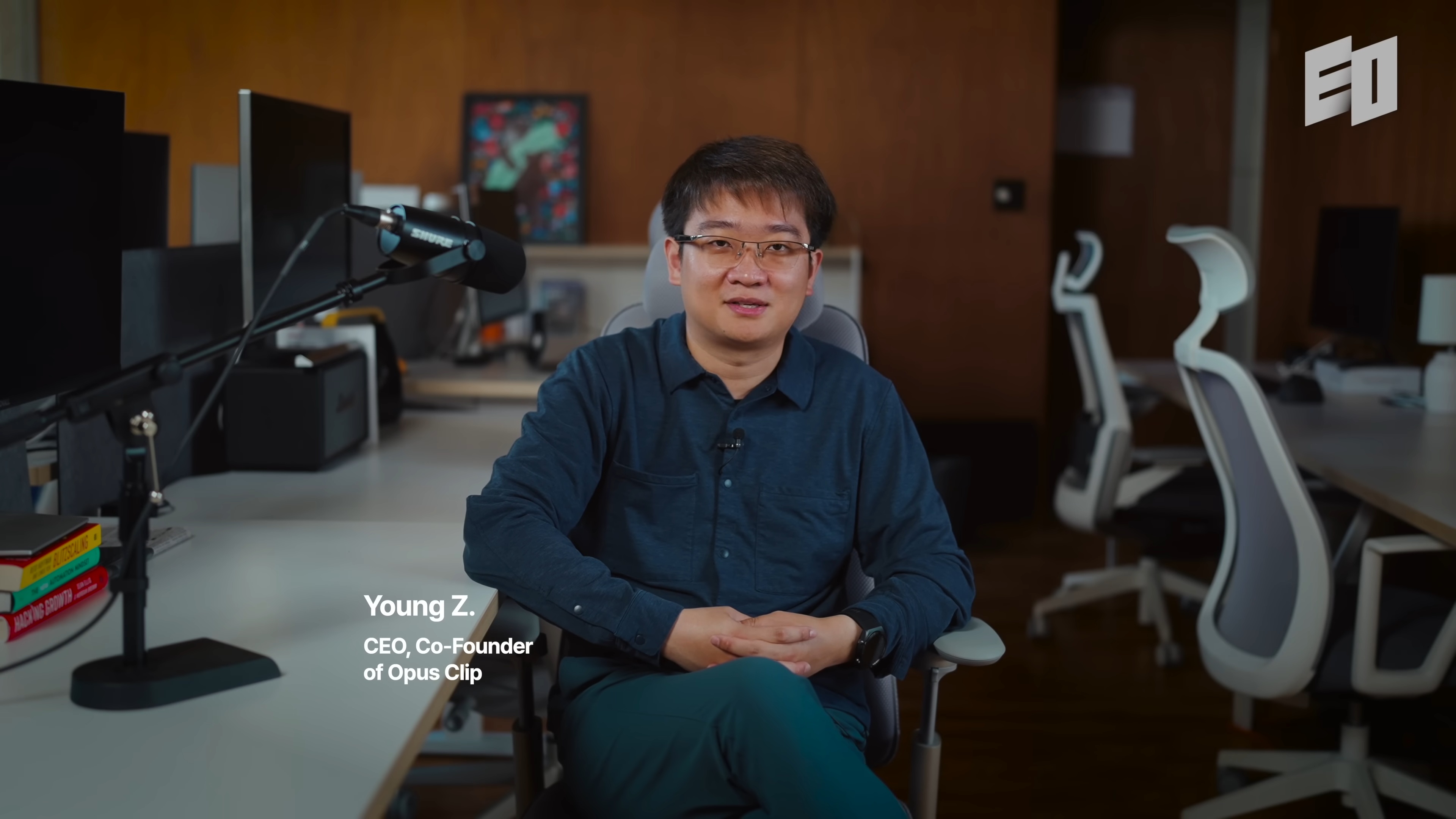 Young Zhao seated beside a microphone during his EO interview in an office