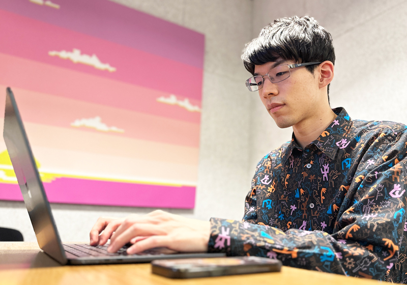 Yuki Kaneko working at a laptop during his Cyber University interview