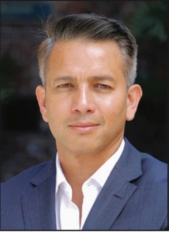 Yuri Sudhakar in a blue jacket and white shirt in a published press portrait