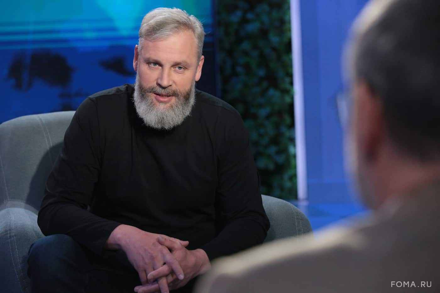 Yury Uskov speaking with interviewer Vladimir Legoyda in a television studio