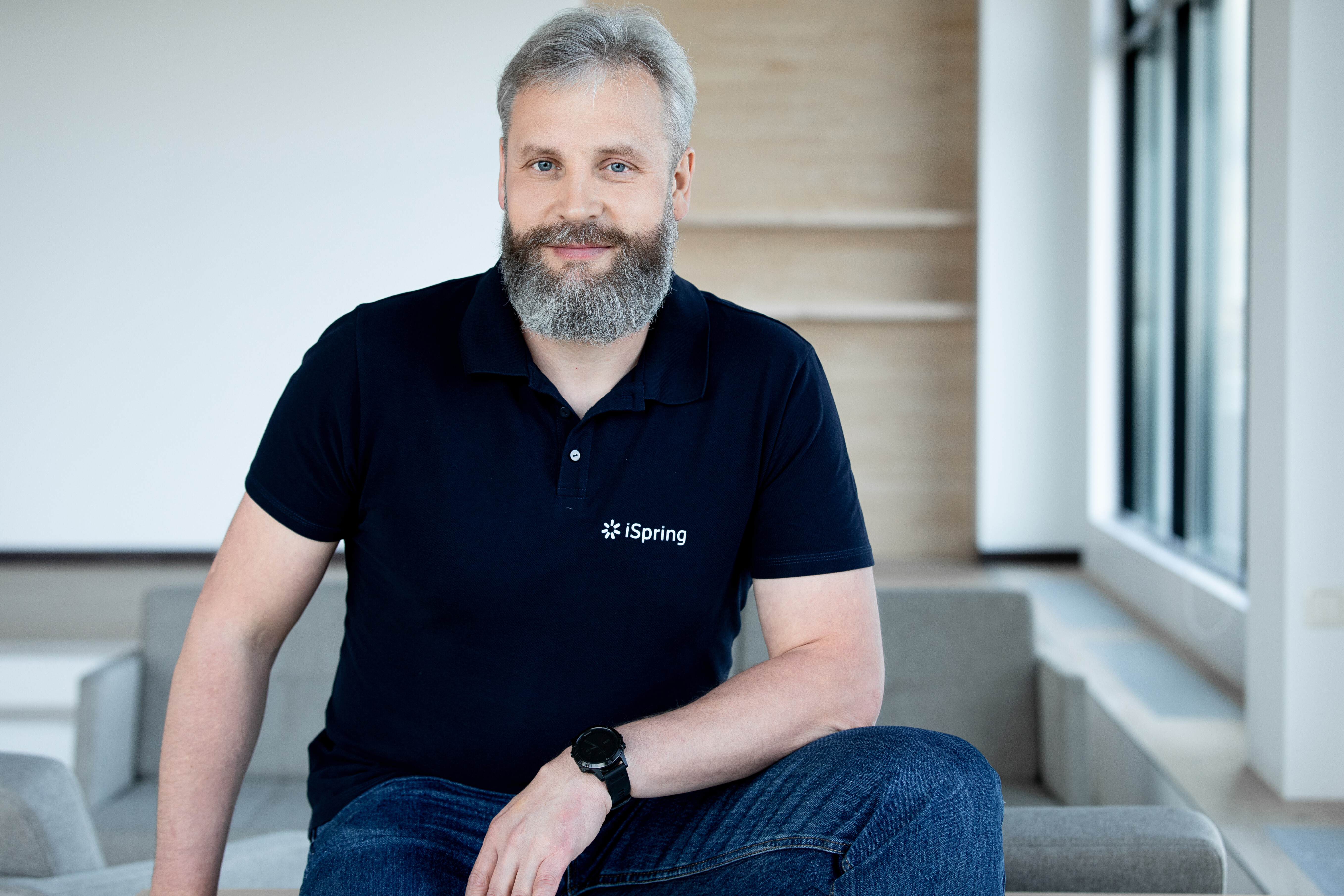 Yury Uskov seated in an iSpring polo shirt