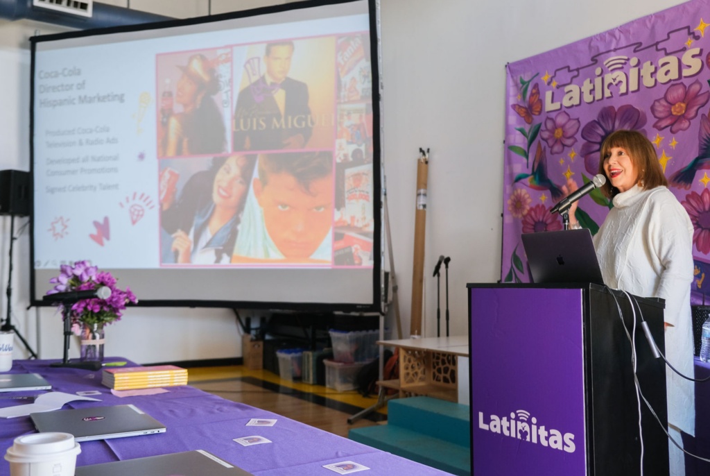 Bonnie Garcia speaking beside a presentation about her Coca-Cola career at Startup Chica San Antonio