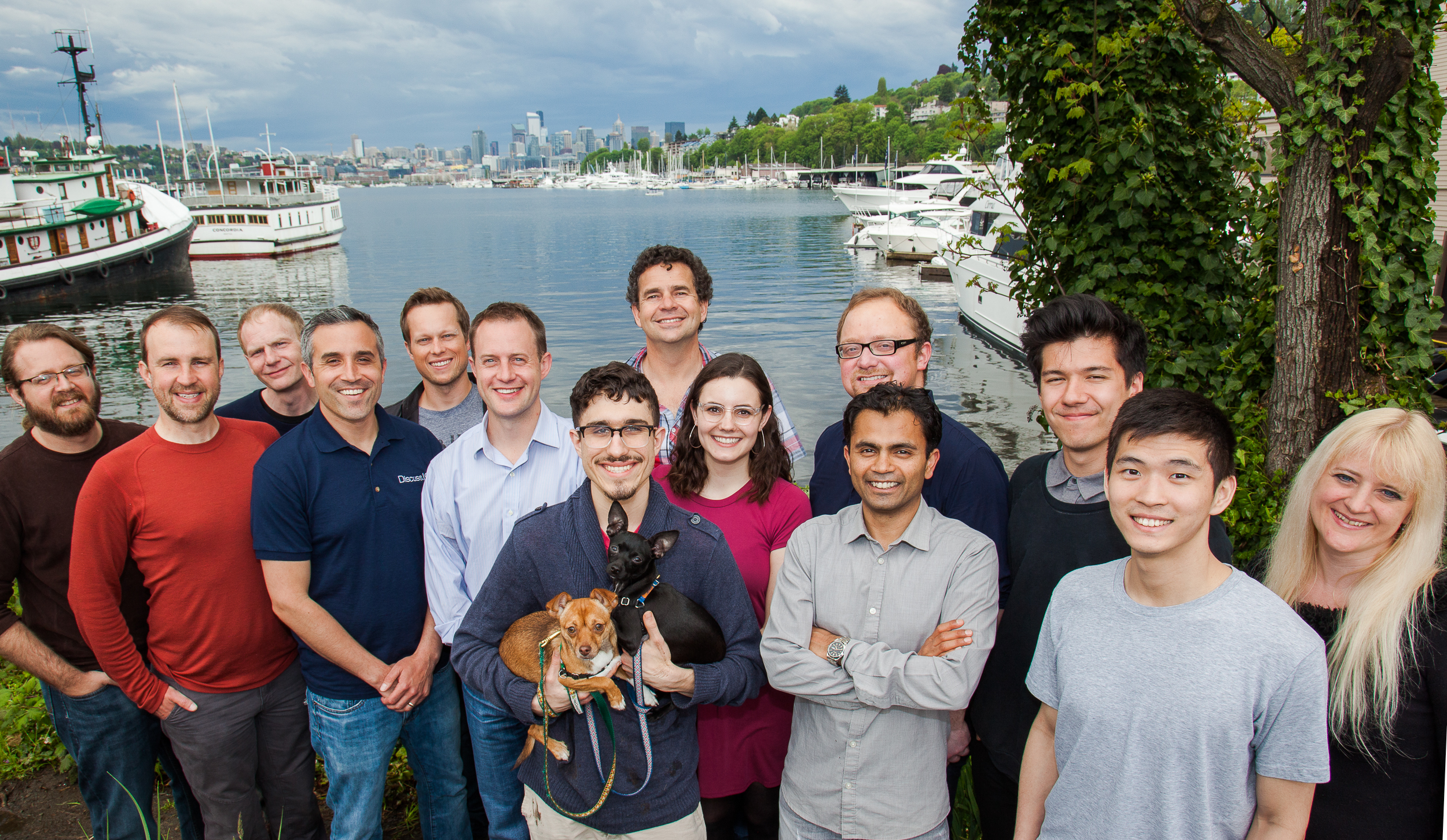 Zach Simmons with the Discuss.io team beside Seattle’s Lake Union, with two dogs in the foreground