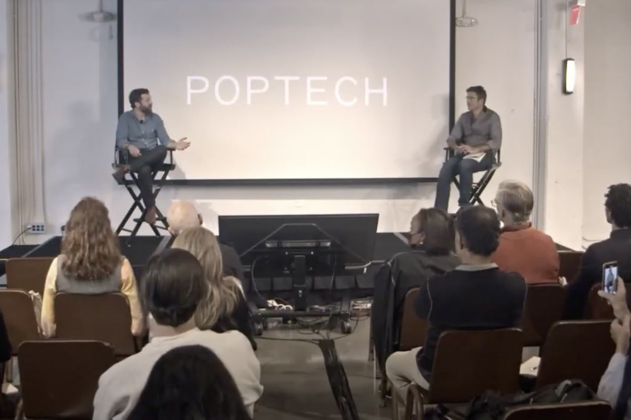 Zack Parisa speaking with Michael Coren on the PopTech stage in front of an audience