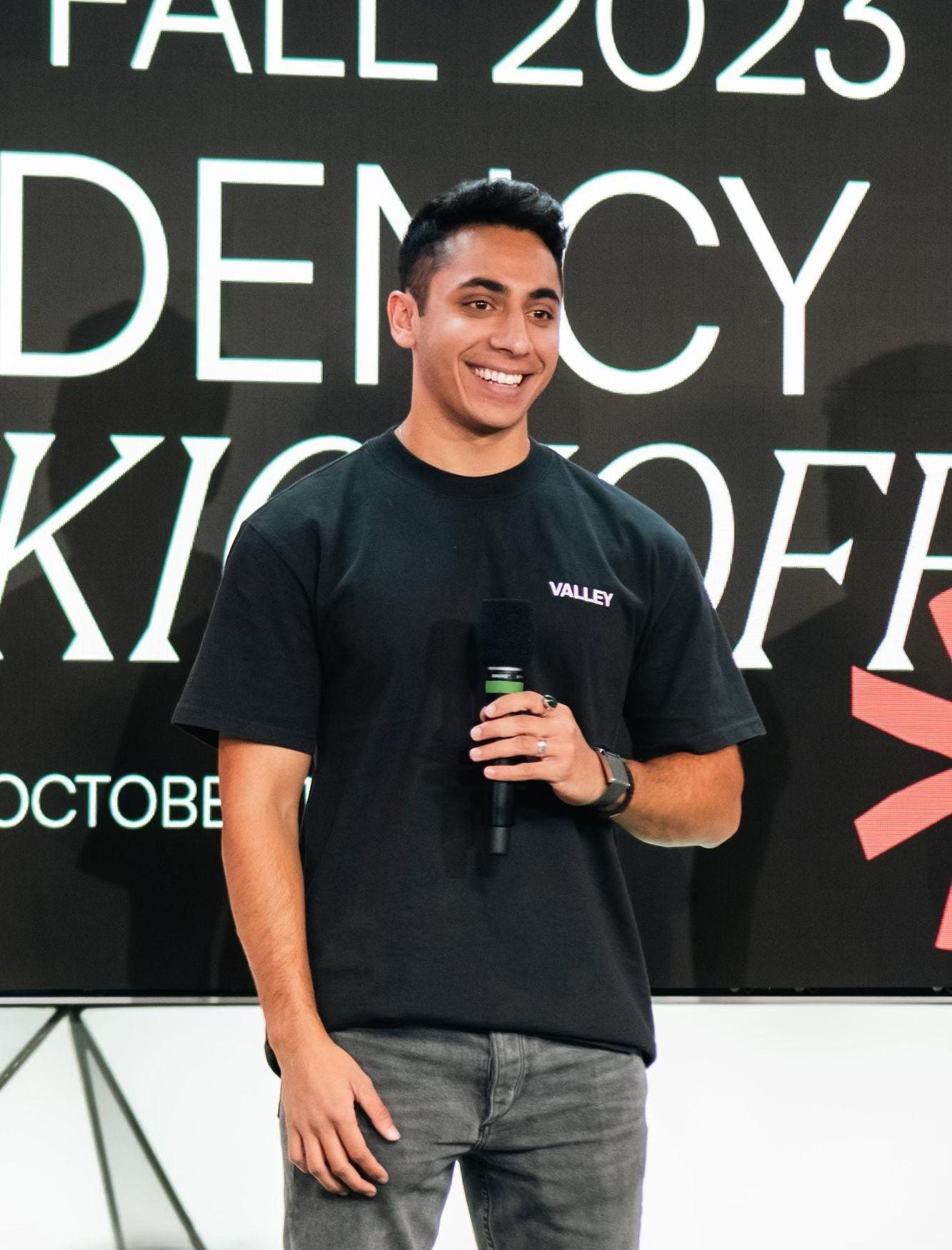 Zayd Syed Ali holding a microphone in a Valley T-shirt at the fall 2023 kickoff