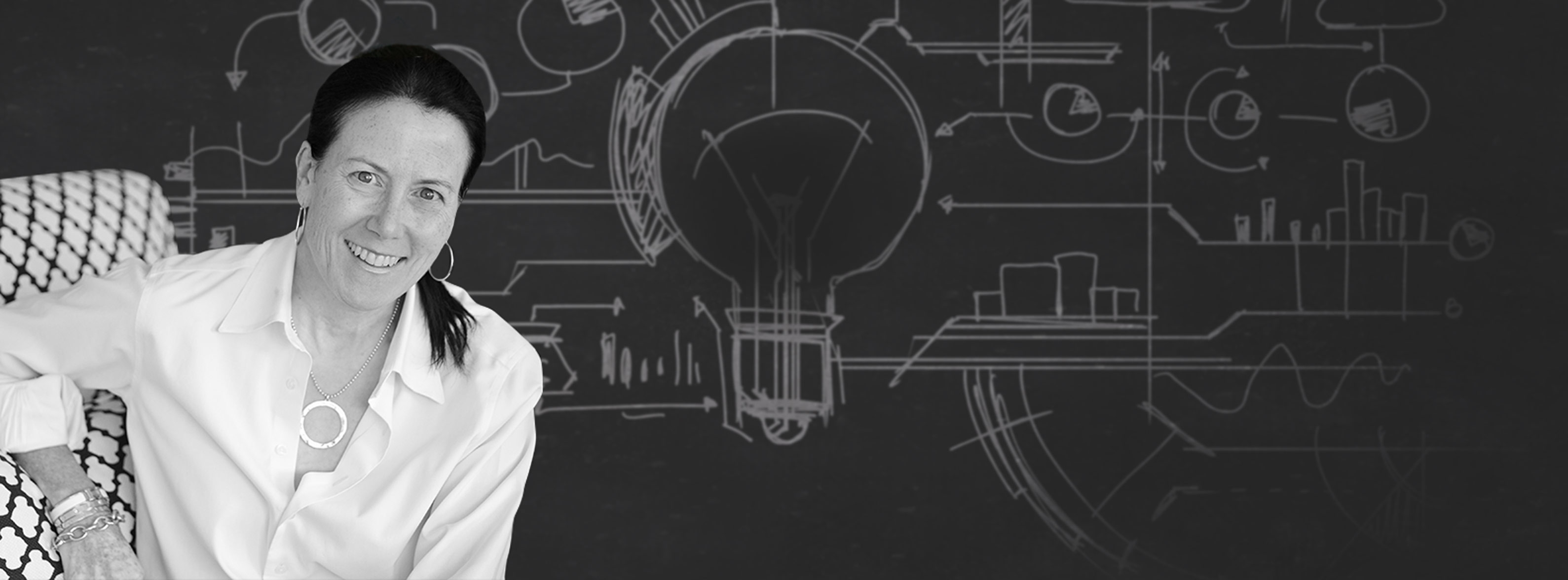 Zer0 to 5ive founder Michelle Pujadas seated in front of a wall covered in diagrams