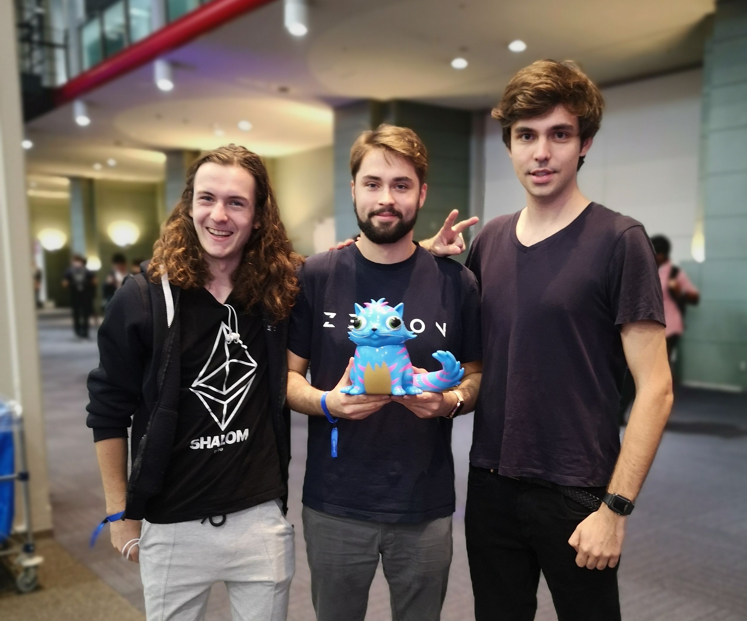Three members of Zerion’s early team posing with a colorful toy creature