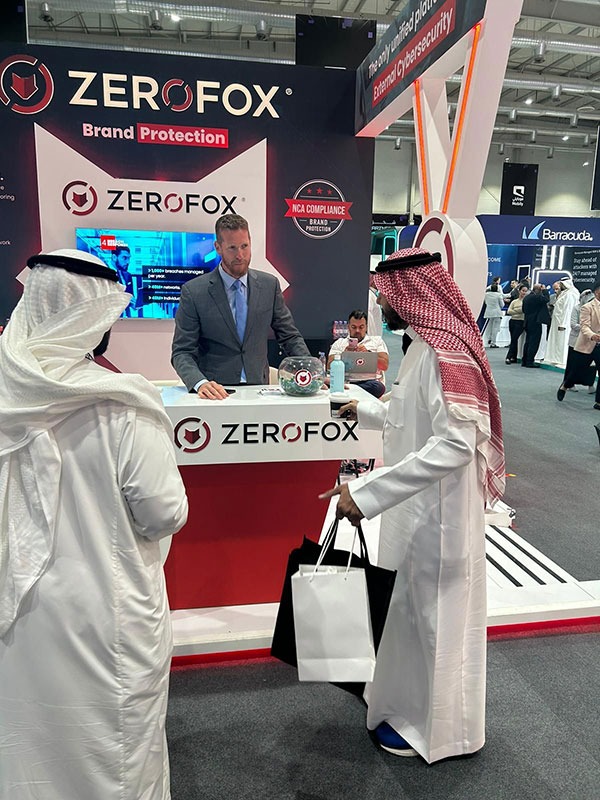 ZeroFox representatives meeting visitors at a cybersecurity exhibition booth.