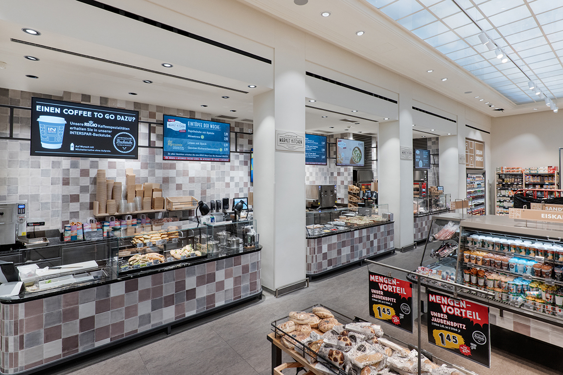 Digital menu screens above the INTERSPAR Schottentor food counters in Vienna