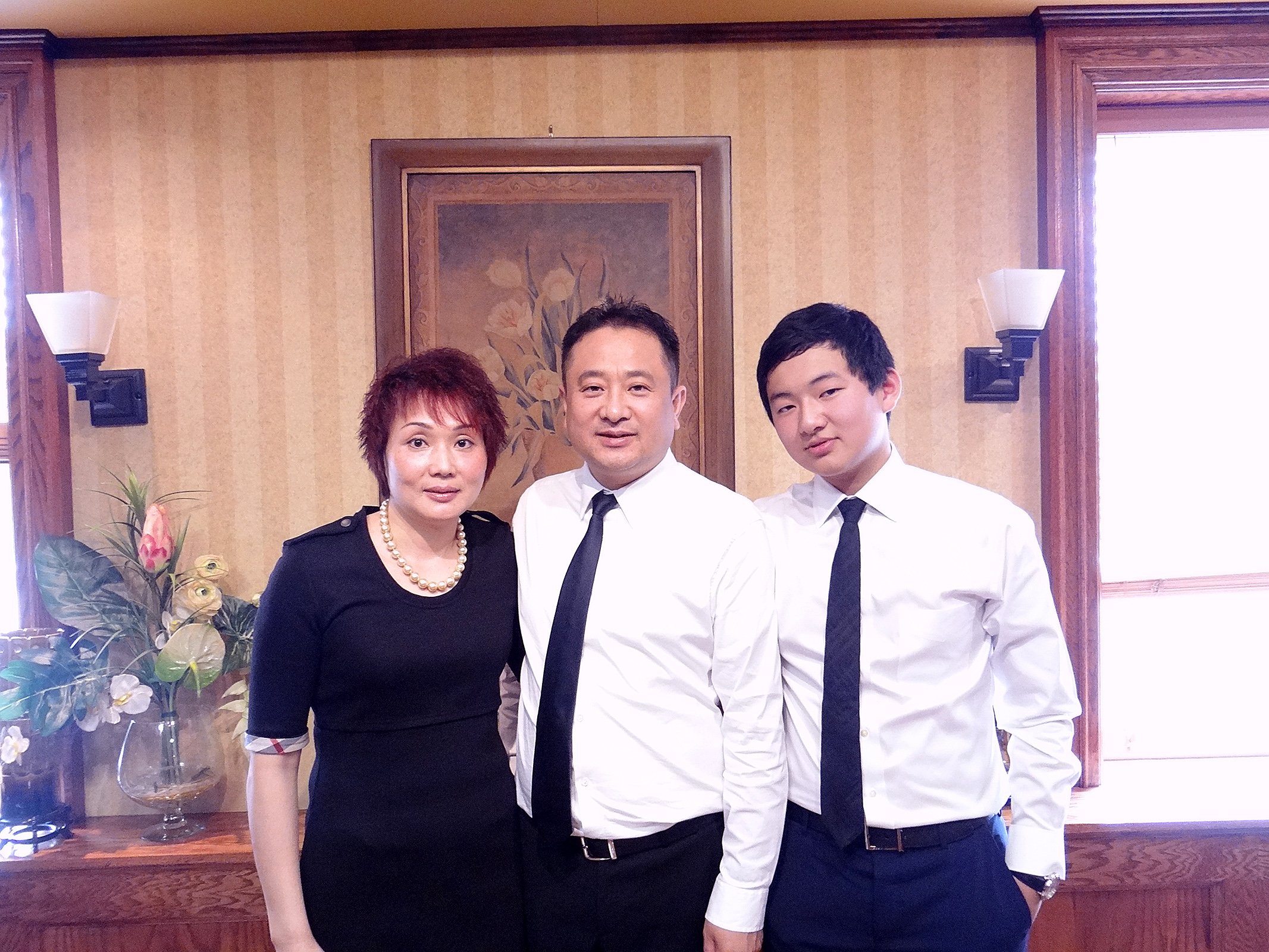 Chan Sin Wong, Zhou Min Ni and their son standing together