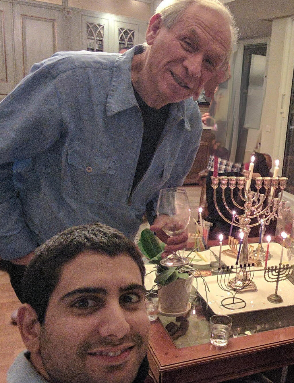 Zohar Zisapel and Ofer Ben-Noon celebrating Hanukkah beside lit candles