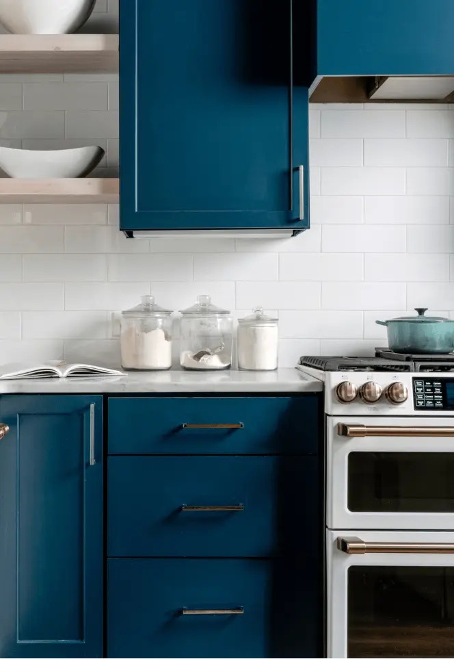 Blue kitchen cabinetry, storage jars, and cookware in Zola’s registry photography