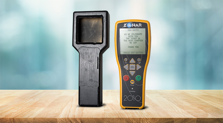 Zonar’s wooden inspection-device prototype beside a yellow Zonar 2010 handheld