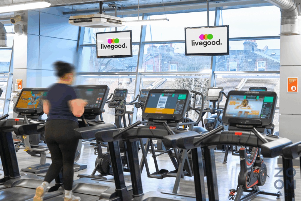 A member exercising at Places Leisure beneath two livegood television screens