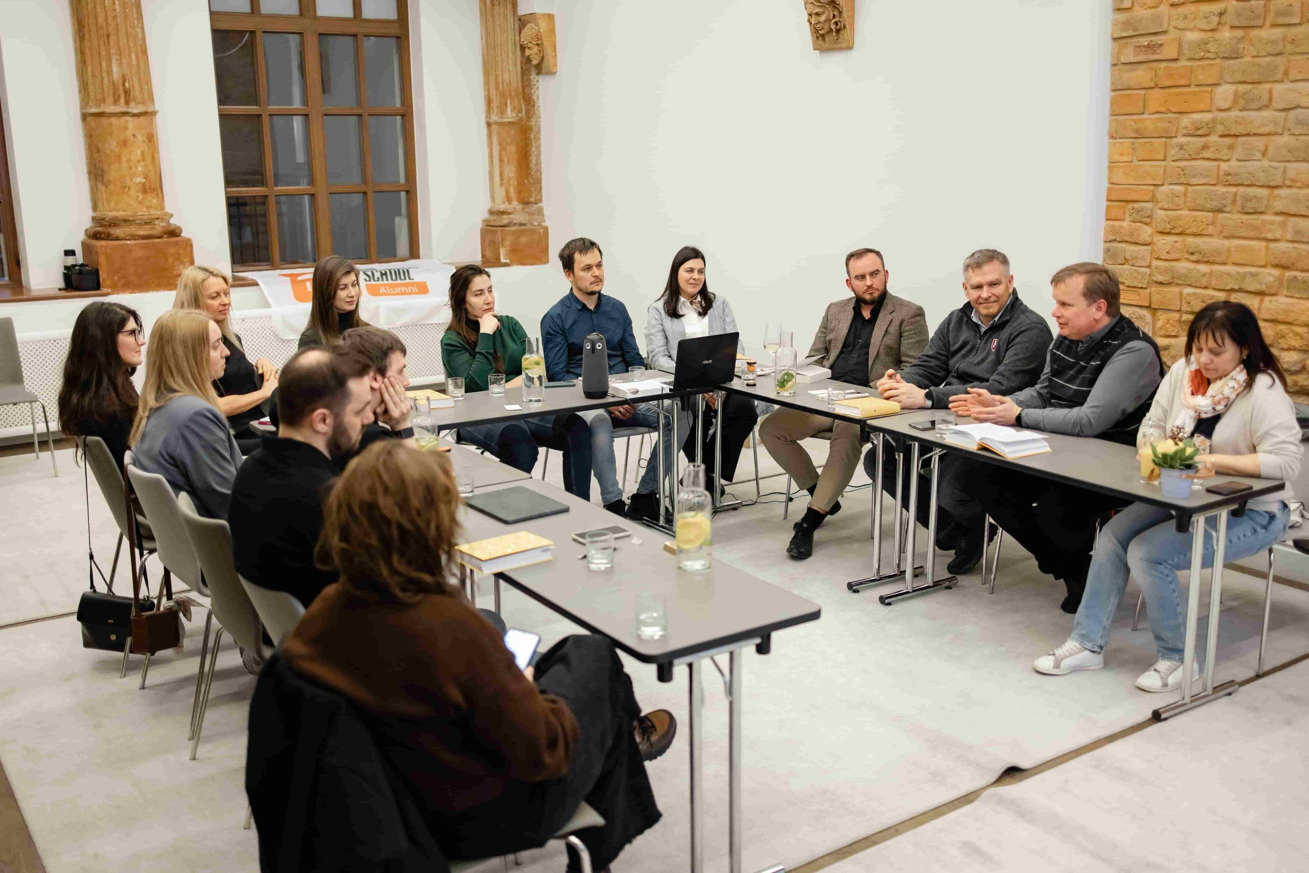 Zoryan Hudziy seated with participants at a UCU Business School book-club discussion in Lviv