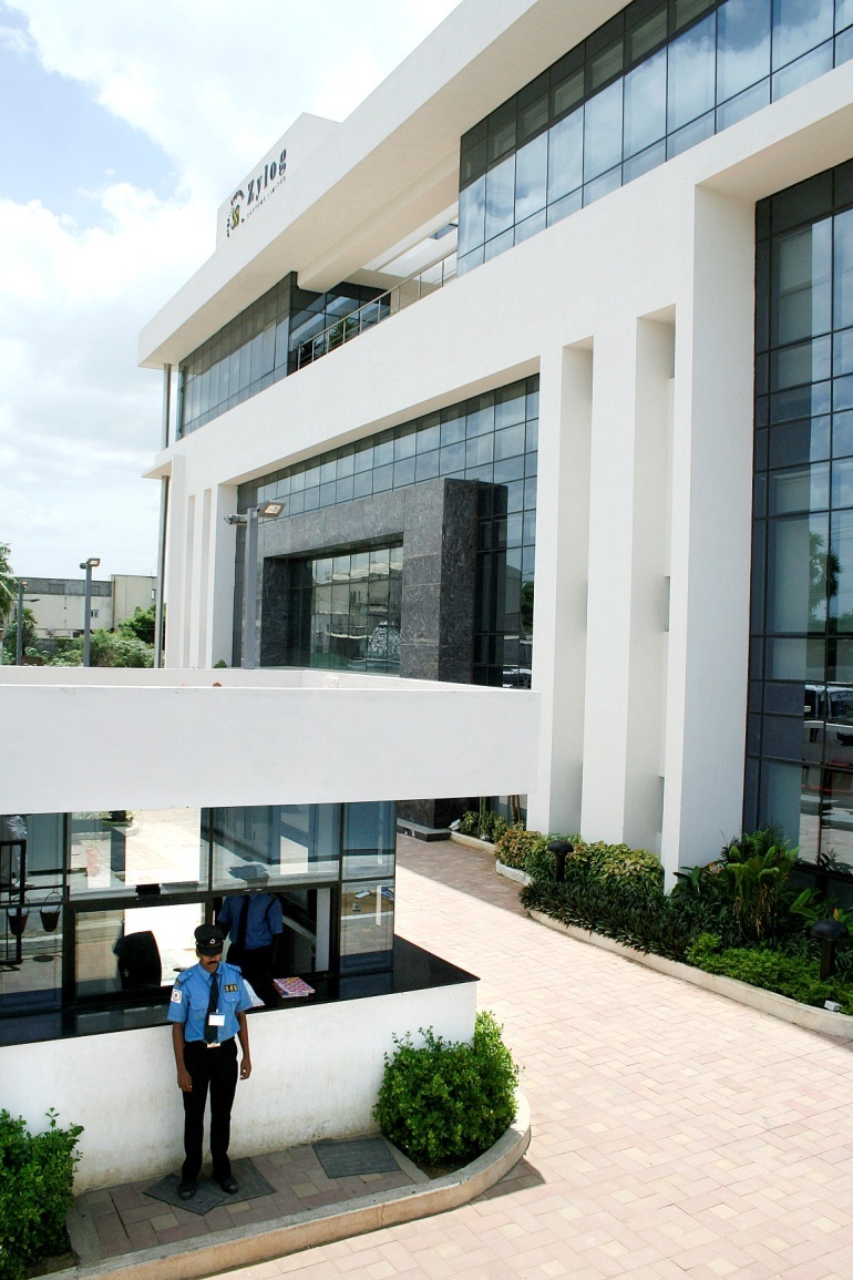Archival Zylog office building with glass windows and a guard at the entrance