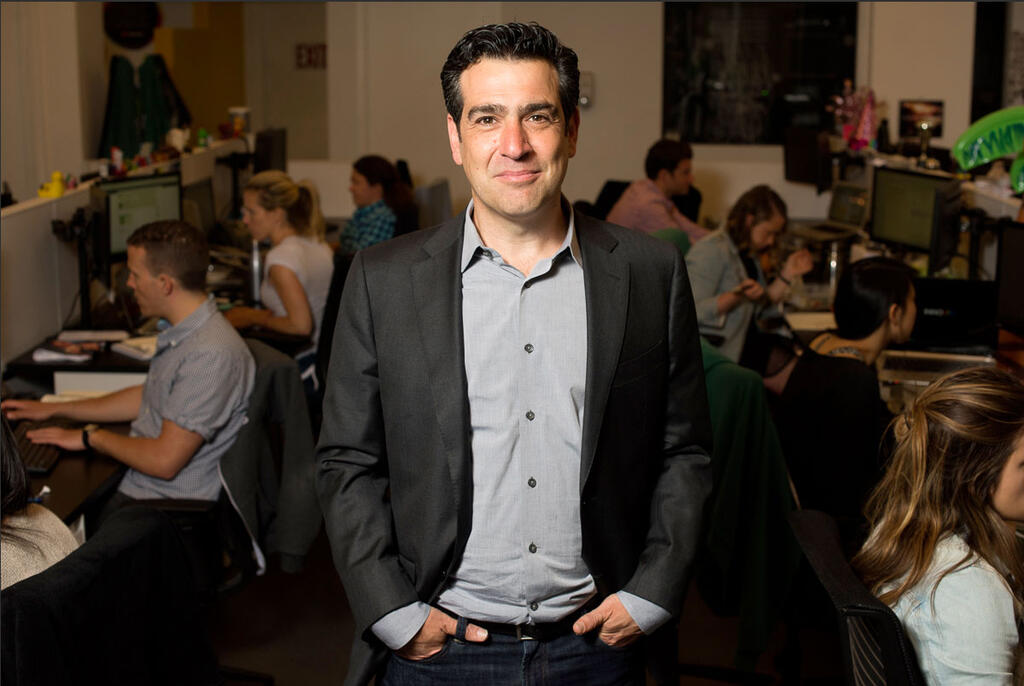 Zvika Netter standing in an open Innovid office among colleagues