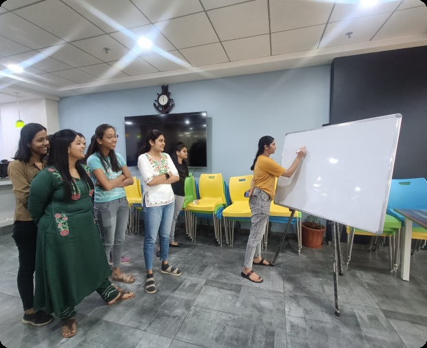 Zymr colleagues gathered around a whiteboard in an office